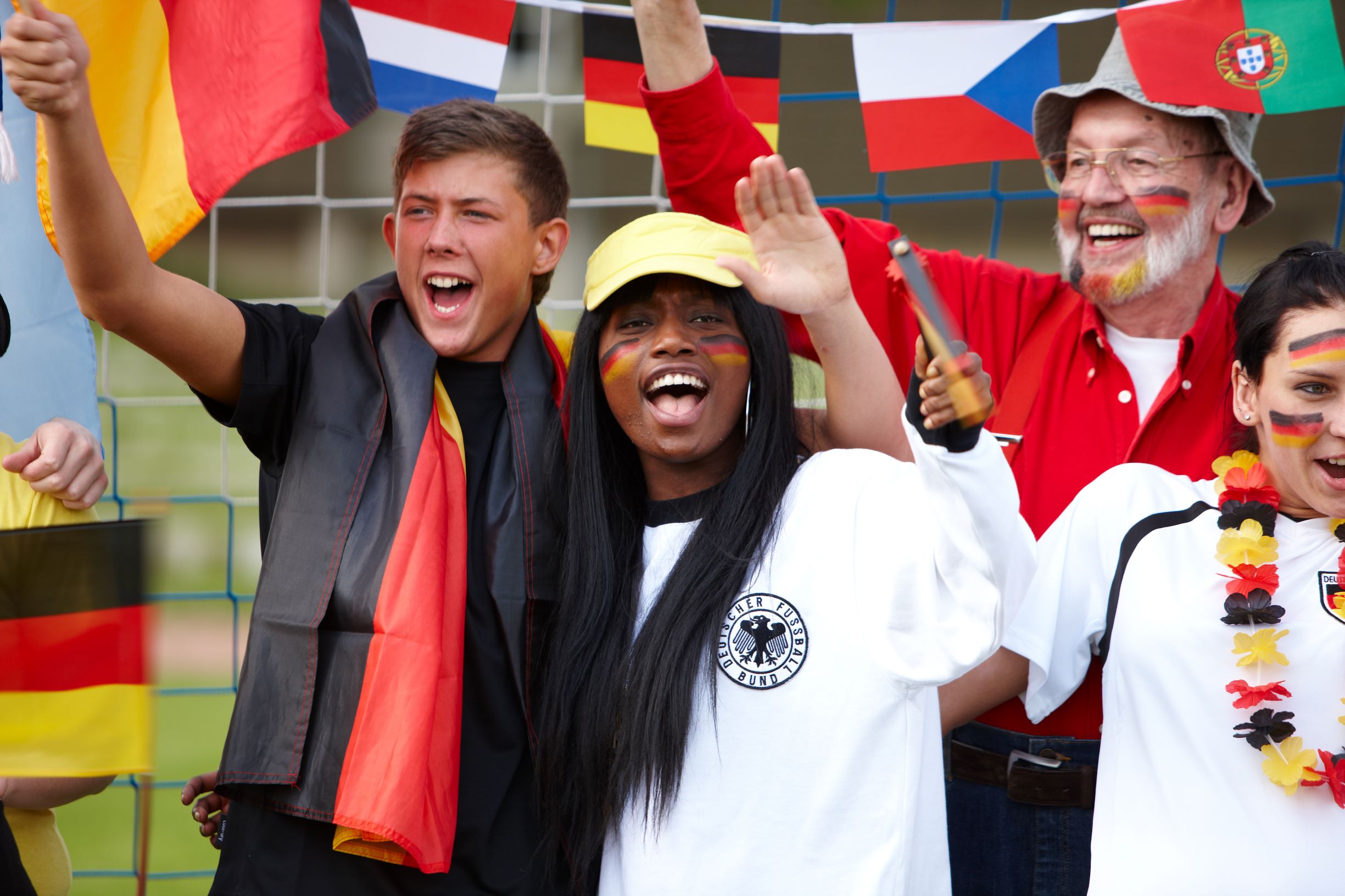 Jubelnde Fußballfans im Stadion internationale Flaggen