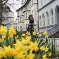 A young woman is riding her bike wearing a helmet, as recommended by the police.