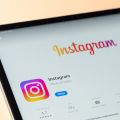 auf einem Tablet ist die App Instagram geöffnet. Der Hintergrund ist hell orange.