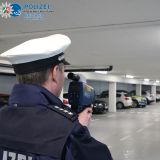 Lasermessender Polizeibeamter steht in einem Parkhaus