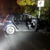 Zur Nachtzeit steht ein verunfallter Renault mit geöffneten Türen vor einem Laternenpfahl. Auf dem Beifahrersitz steht augenscheinlich ein Tresor.