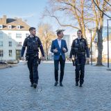 Auf dem Bild sind drei Personen zu sehen, die nebeneinander gehen.