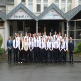 Auf dem Bild sind Polizeibeamtinnen und Polizeibeamte zu sehen, die teilweise Uniform tragen und für ein Gruppenbild zusammenstehen.