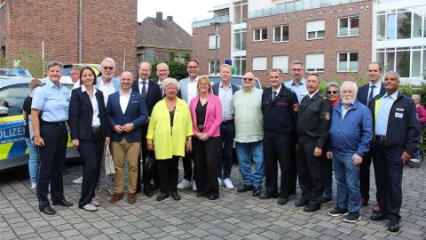 Gruppenbild und in Teilen ein Streifenwagen auf der linken Seite