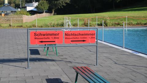 Hinweisschild am Beckenrand: links Schwimmerbereich, rechts Nichtschwimmerbecken