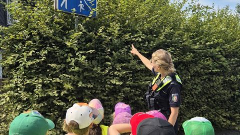 Polizeibeamtin übt mit Vorschulkindern das richtige Verhalten in der Spielstraße