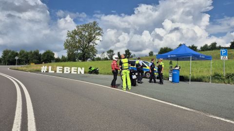 Verkehrssicherheitsberatende im Gespräch mit Biker bei Aktion Hashtag LEBEN in der Applauskurve