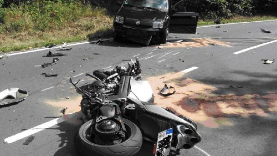 Das Bild zeigt einen Unfallort mit einem beschädigten Motorrad und einem beschädigten Auto.