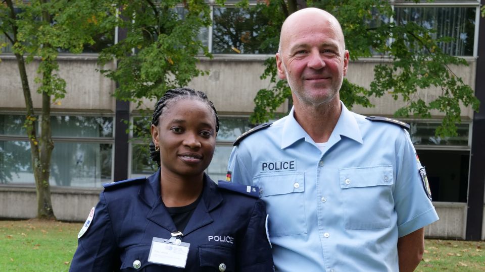 Kriminaldirektor Stefan Schwarz mit Fatou Jallow aus Gambia stehen nebeneinander und blicken in die Kamera.