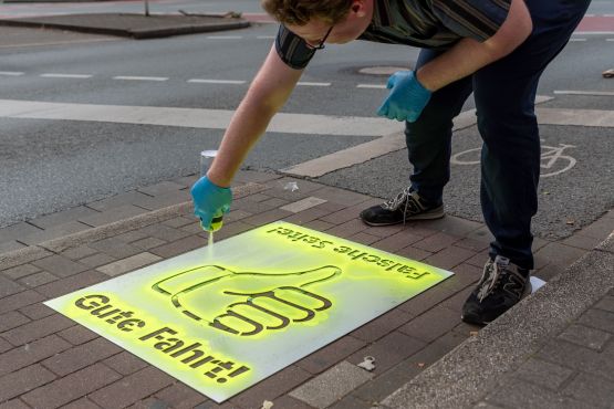 Fabian Menke, Fuß- und Radverkehrsbeauftragter der Stadt, hat am Montag zur Sprühkreide gegriffen. „Daumen hoch“ zeigt an: Die Richtung stimmt, alles richtig, gute Fahrt! „Daumen runter“ bedeutet: Falsche Seite, bitte auf die andere Straßenseite wechseln!