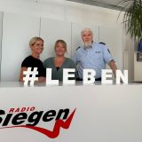 Die Protagonisten der Bürgersprechstunde "Bitte folgen - hier antwortet die Polizei" bei Radio Siegen vom 23. Juli 2025. Zu sehen sind von links nach rechts: Janina Mausberg (Verkehrssicherheitsberaterin der Polizei), Ann-Christin Schmidt (Moderatorin Radio Siegen) und Stefan Pusch (Pressesprecher der Polizei).
